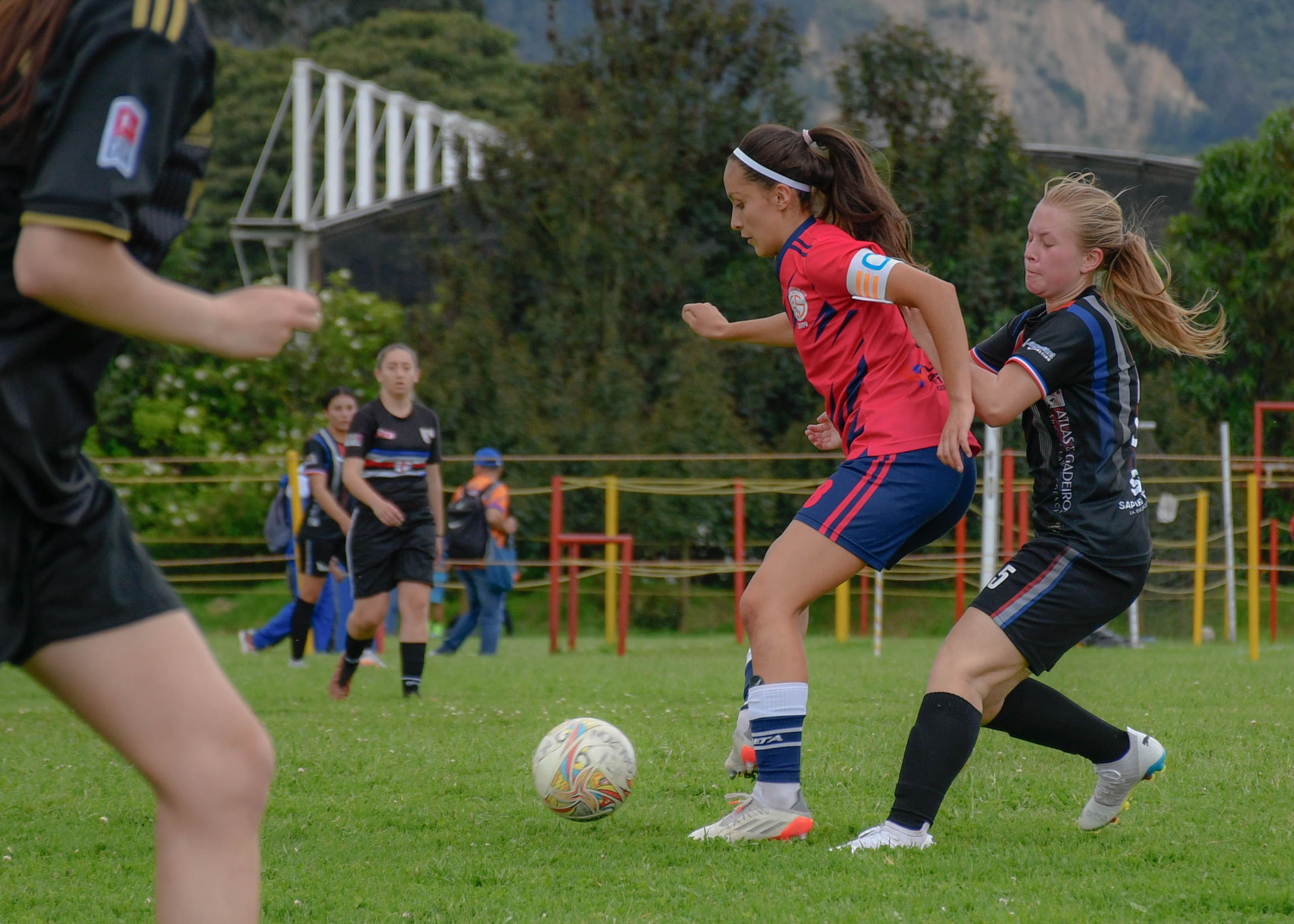 Women footballers competing for the ball during a match